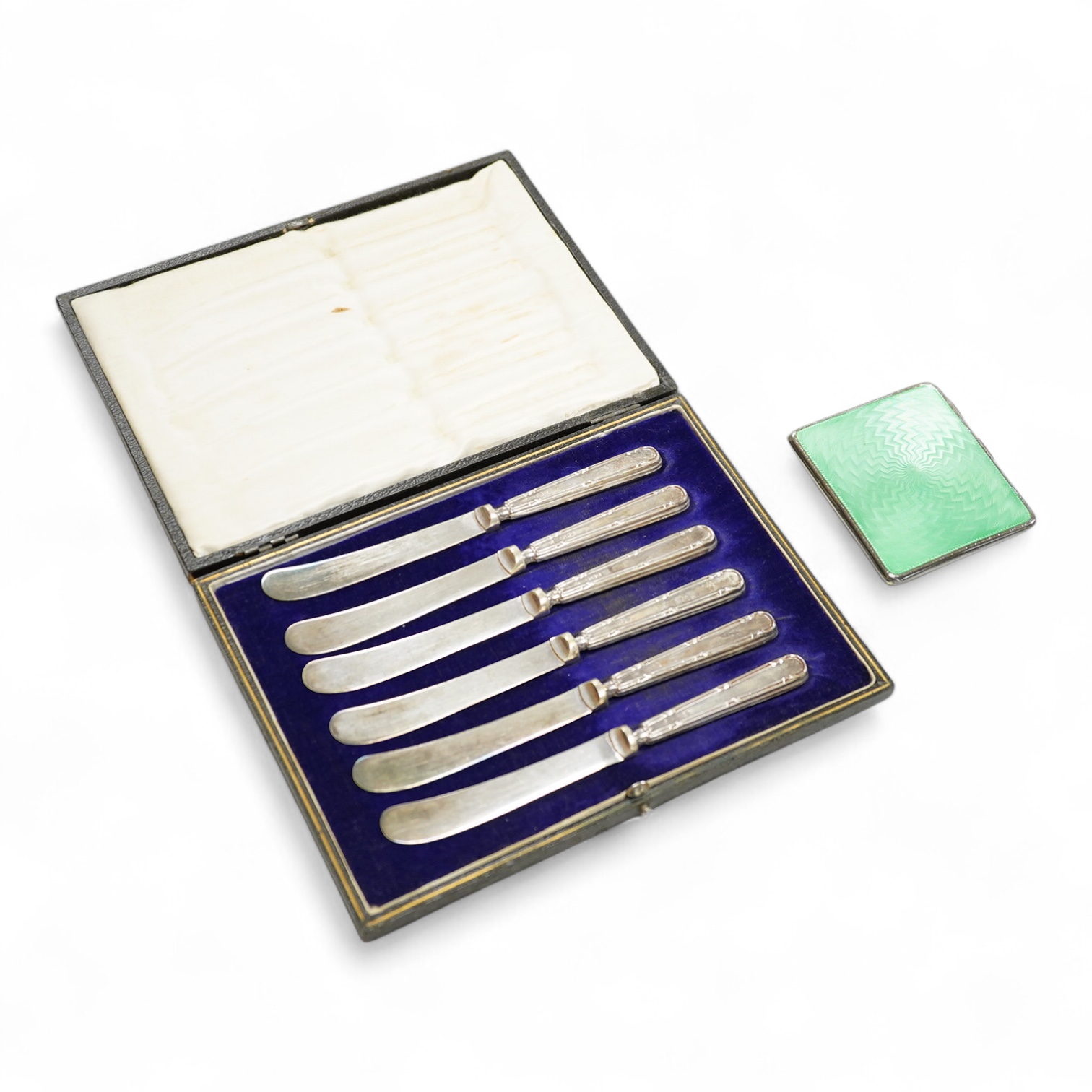 A George V engine turned silver and green enamel cigarette case, by Mappin & Webb, Birmingham, 1932, 82mm and a cased set of six silver handled tea knives.